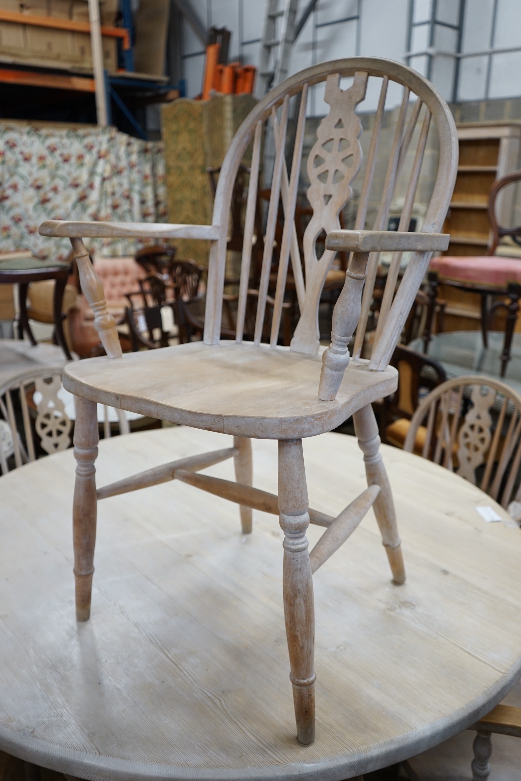 A set of eight Victorian style limed beech Windsor wheelback elbow chairs
